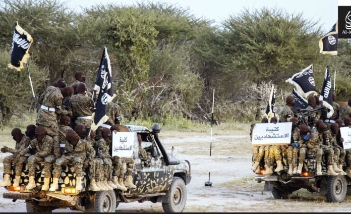 Al-Shabaab militants driving technical vehicles through a dry, rural road