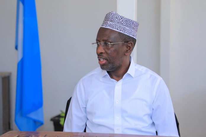 Former President Sheikh Sharif Sheikh Ahmed seated with the Somali flag in the background.